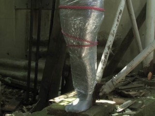 Bondaged and cocooned slave girl in the mystery garden - Full encasement fetish in zentai body bag