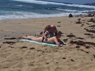 Fille qui bronze seins nus se fait baiser à la plage sur le sable, Naemyia